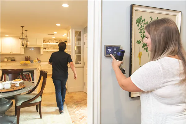 Woman adjusting a smart thermostat