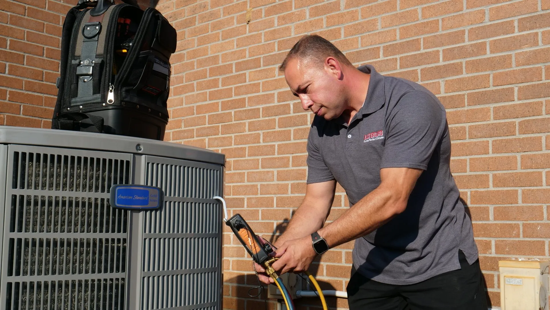 Eastergard HVAC technician checking refrigerant levels on an American Standard Gold Series unit
