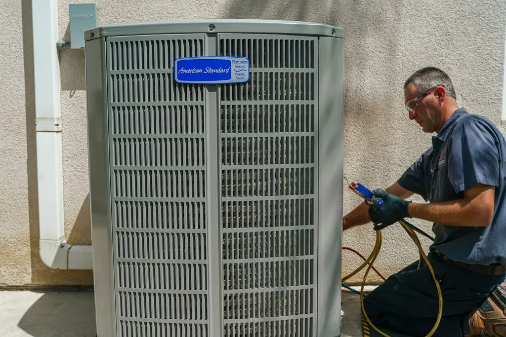 HVAC technician servicing an American Standard Platinum Series outdoor unit