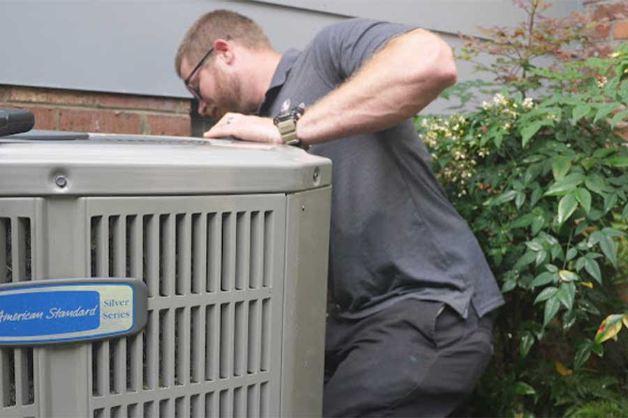 HVAC technician working on an American Standard Silver Series outdoor unit