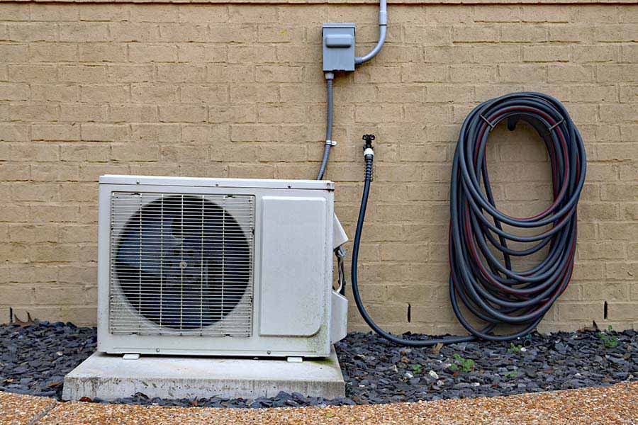 Outdoor ductless mini-split condenser mounted on a concrete pad