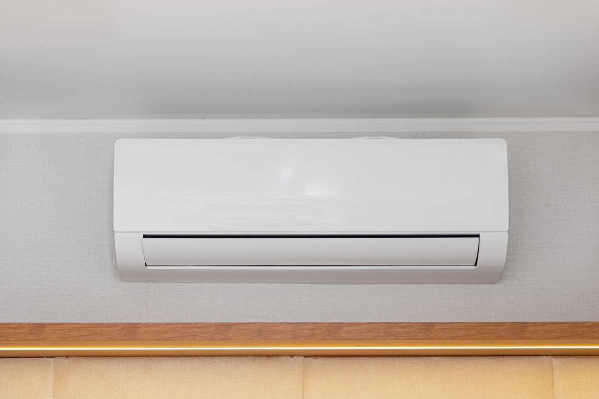 White Air Conditioner Mini Split Unit Mounted at Wall in Room