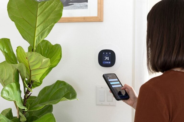 Woman programming a smart thermostat
