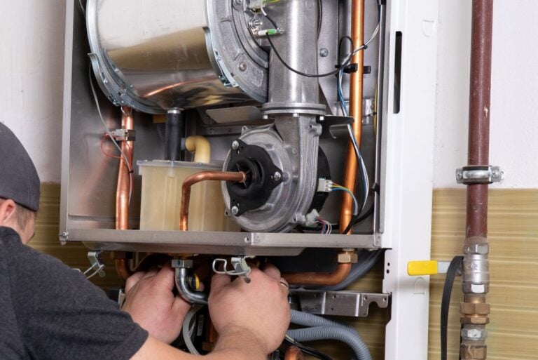 plumber fixing central heating system, Worker servicing a gas boiler