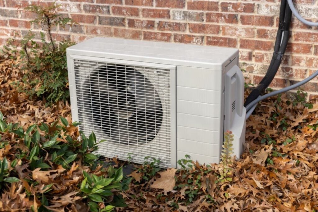 Air-conditioning-unit-surrounded-by-fall-leaves