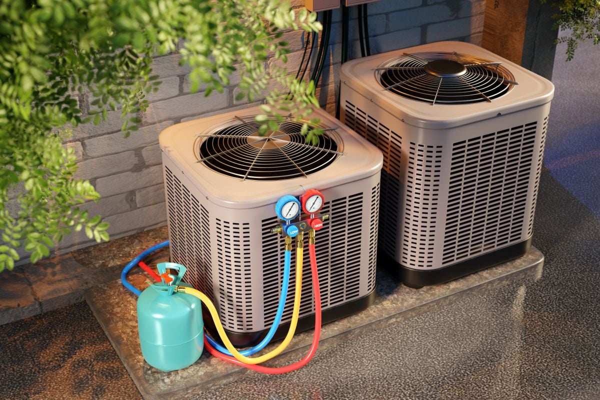 HVAC maintenance with refrigerant gauges and gas cylinder connected to outdoor air conditioning units