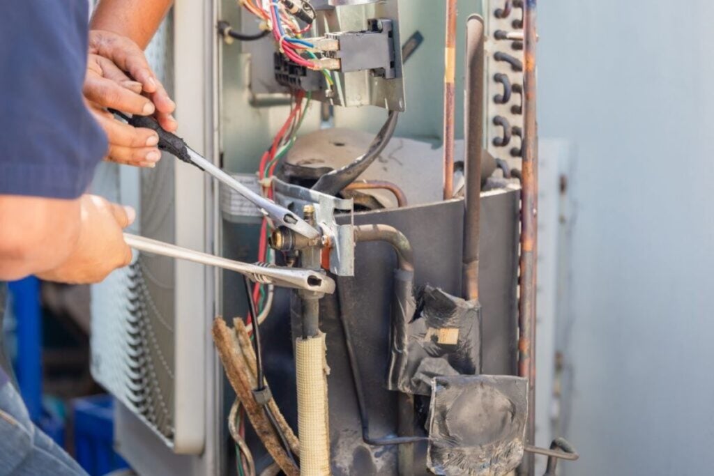 Technician-man-using-a-wrench-fixing-modern-air-conditioning-system-1024x683