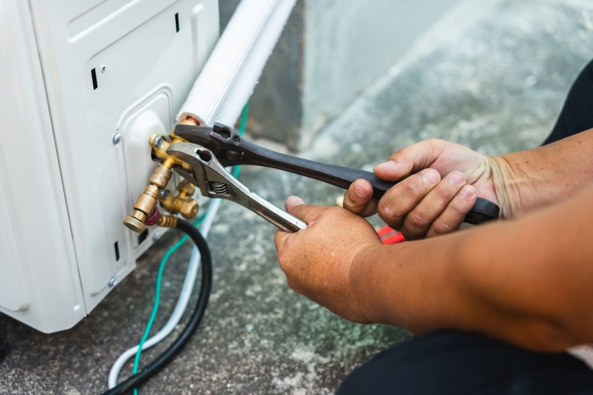 Air conditioner technician hands using wrench