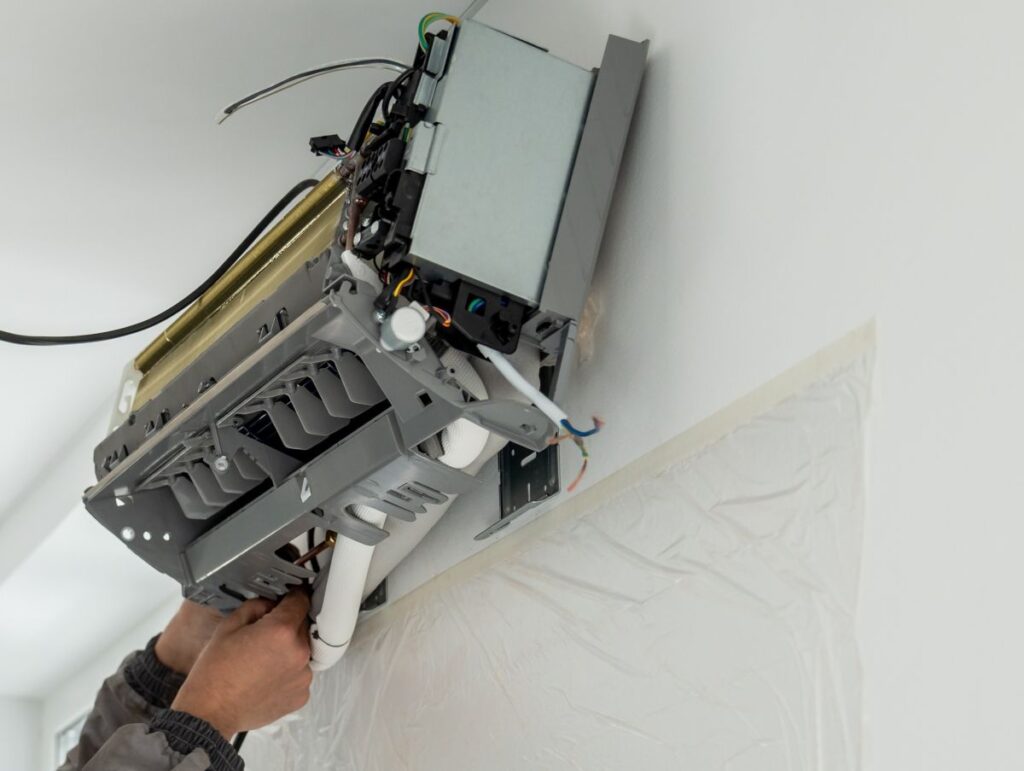 technician worker in uniform installing ductless mini split AC