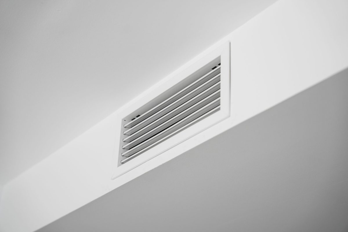 hvac zoning system Close-up of a white ceiling ventilation grille in a modern residential interior, showcasing HVAC airflow design, minimal architecture, clean surfaces and contemporary home style.