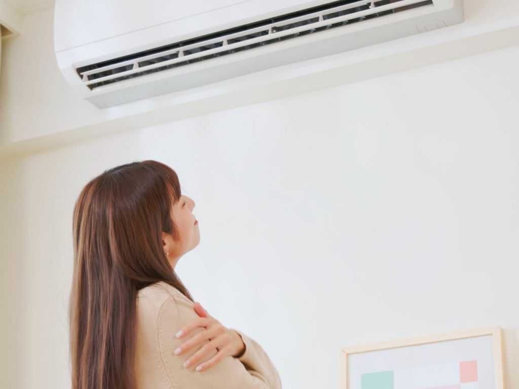 hvac financing options asian woman turn on heater and feel warm in winter standing at home