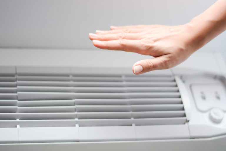hvac warranty hand in front of unit