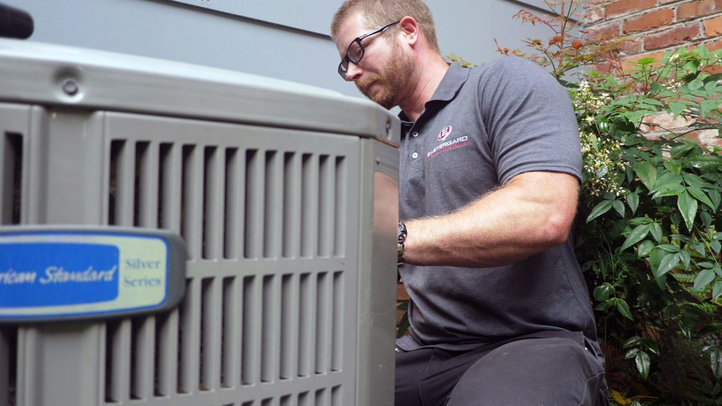 hvac warranty worker fixing outdoor unit