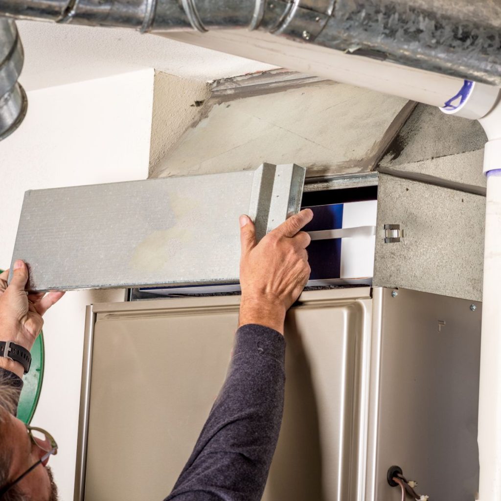 gas furnace vs electric furnace guy inspecting unit